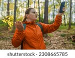 Angry woman tourist hiker hand holding smart phone searching signal in the forest. Communication, cellular problem, bad connection. No signal cellphone network. No communication coverage, lost contact