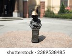 Woman touches small bronze figures of gnomes on the streets of Wroclaw. Europe. High quality photo