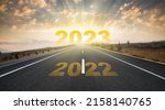 Small photo of 2023 anniversary. Transition from 2022 to the new year. Golden sunrise on asphalt empty road. New year concept with the number 2023 on the horizon.