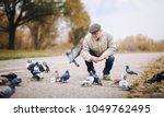Man Feeding Pigeons In The Old...