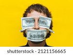 Small photo of The man's face, eyes, mouth and ears are covered with dollar bills. Bribe, corruption and greed concept. Yellow background.