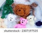 Small photo of Soak toy teddy bears in laundry detergent water dissolution before washing. Laundry concept, Top view
