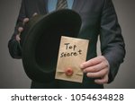 Small photo of Top secret concept. Open the secret. Business man takes out secret documents from his hat. Confidential dossier information. Super important information.