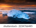 part of iceberg on the famous beach of iceland view at sunrise