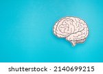 Small photo of A brain shape made from paper on a blue background. Awareness of Alzheimer's, Parkinson's disease, dementia, stroke, seizure, or mental health. Neurology and Psychology care. Top view. Space for text