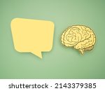 Small photo of Yellow speech bubble and brain shape made from paper on a green background. Awareness of Alzheimer's, Parkinson's disease, dementia, stroke, seizure, or mental health. Neurology and Psychology care