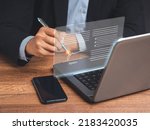 Electronic signature. A businessman in a suit uses a pen to sign electronic documents on digital documents on a virtual screen. Technology, document management, and paperless office concept