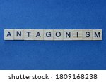 Small photo of gray word antagonism in small square wooden letters with black font on a blue background