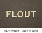 Small photo of gray word flout made of wooden letters on brown background