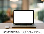 Empty space,Wooden Computer Desk and Laptop with blank screen and wireless mouse in office with modern blurred background light bokeh.- Image
