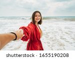 Small photo of Young woman hold man's hand and walking in ocean by sand beach. Enjoying moment together with her boyfriend. Get rest on island or piece or paradise on earth. Cheerful smile