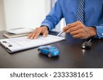 Small photo of The car dealers of the car showrooms bring the car sales contract documents to the customers and explain the loan and interest rates to the customers before signing the sales contract for accuracy.
