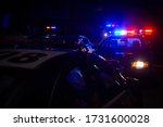 Blue and red police lights on squad cars during a night time traffic stop, with space for text on the left