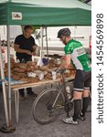 Small photo of London, UK - July, 2019. A cyclist buying bread in an organic bakery stall in Brockley market, a local farmer's market held every Saturday in Lewisham.