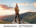 Happy Bearded Man reaching the destination and on the top of mountain at sunset on autumn day Travel Lifestyle concept The national park Lake District in England