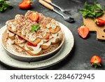 Tiramisu. Homemade tiramisu cake with fresh strawberry, mascarpone and mint. Tiramisu portion on plate. top view. place for text.