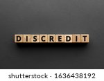 Small photo of Discredit - words from wooden blocks with letters, loss of reputation or respect discredit concept, top view gray background