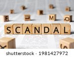 Small photo of Scandal - word wooden blocks with letters, affray fracas scandal concept, random letters around, paper background