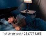 Small photo of Peaceful young man sleeping in a comfortable bed alone at home, enjoying his orthopedic mattress and cozy pillow. Good sleep concept. Copy space