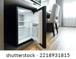 Black mini small fridge refrigerator under the frame wooden counter in hotel resort bedroom