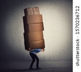Small photo of Bent down guy carrying a lot of big heavy boxes on his back. Overloaded of daily tasks, and difficult burden. Packing stuff and moving concept. Mail worker package delivery before christmas holidays.