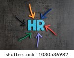 Colorful arrows pointing to the word HR at the center on black cement blackboard wall, represent Human Resource department, hiring new job or position in company.
