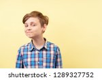 Small photo of mocking jeering scoffing boy with ironical smile over yellow background, advertisement, banner or poster template, emotion, people reaction