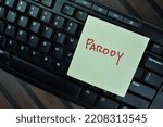 Small photo of Concept of Parody write on sticky notes with keyboard computer isolated on Wooden Table. Selective focus on parody text