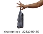 Woman's hand holding used men's underwear on white background The picking sensation looks disgusting when handling used clothing.