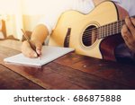 soft and blur focus.song writer holding pencil compose a song.musician playing acoustic guitar.empty space for text.concept for live music festival.Instrument on stage,abstract musical background.