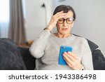 Small photo of Worried senior woman staring at a smartphone screen at home, upset retire female lying down on the couch looks at mobile phone with vexation, read terrible news or received bad analysis results