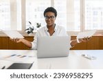 Small photo of Worried puzzled African-American female office employee sitting inside at the desk and looking through working papers, contracts, confused woman found mistake or inconsistency in annual report