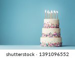 Small photo of Birthday cake with three tiers and colorful sprinkles
