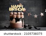 Chocolate birthday cake with  chocolate ganache drip icing and happy birthday banner