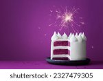 Purple birthday celebration layer cake with white frosting and celebration sparkler against a purple background