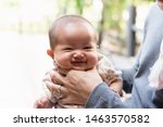 Small photo of Close up of asian father is holding his baby neck to belch burping after breastfeeding. Father spending time with his daughter outdoor. Maternity and baby care.