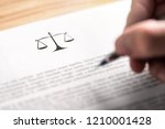 Small photo of Attorney, lawyer, solicitor or jurist working on a business brief in law firm. Legal contract, clause or article paper. Man writing document with scale icon and sign with pen. Judge making decision.