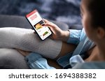 Food delivery app in mobile phone. Restaurant order online. Woman using smartphone to get take away lunch home delivered. Fast courier service. Burger menu mock up in cellphone screen.
