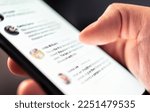 Small photo of News feed in social media, post message, comment and profile page in mobile phone. Online conversation in digital community network blog. Swipe smartphone screen with finger. Holding cellphone in hand
