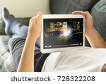 Online movie stream with mobile device. Man watching film on tablet with imaginary video player service.