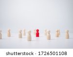 Small photo of A wooden figure standing with a team to influence and empowerment. Concept of leadership, successful competition winner and Leader with influence and Social distancing for a new normal lifestyle