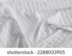 Small photo of Quilted fabric. The texture of the blanket. White textile ffffff