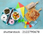 Small photo of Colorful kite and fasting food for Clean Monday on turqoiuse table