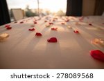 With rose petals on the bed
