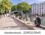 Small photo of Paris, France - circa June 2022: People hang out along the canal in the Canal Saint Martin area.