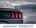 American muscle car stylized in black and white with red accent tail light