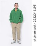 Small photo of a handsome attractive full body back young man in a green sweater ,khaki pants with handbag stands in studio