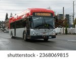 Small photo of Everett, WA, USA - September 26, 2023; Everett Transit electric bus in red and gray livery on wet city street