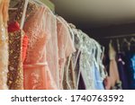 Small photo of Many ladies evening gown long dresses on hanger in the dress rent shop for the wedding day. Dresses rental concept. Wedding dress for the wedding.selective focus.Ball gown rental concept.