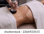 Small photo of procedure removing cellulite on female abdomen, cavitation belly massage. Ultrasonic massage for weight loss. Correction of female figure without surgical intervention. Closeup of the tummy